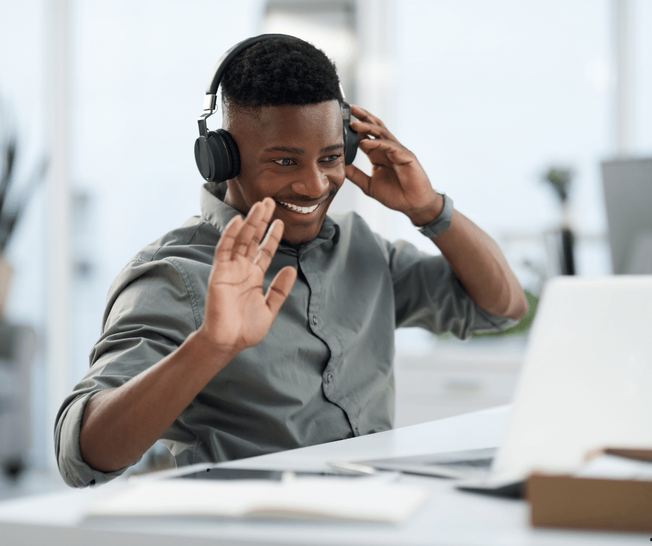 Man with headphones sitting at desk attending an online PTSD therapy session.